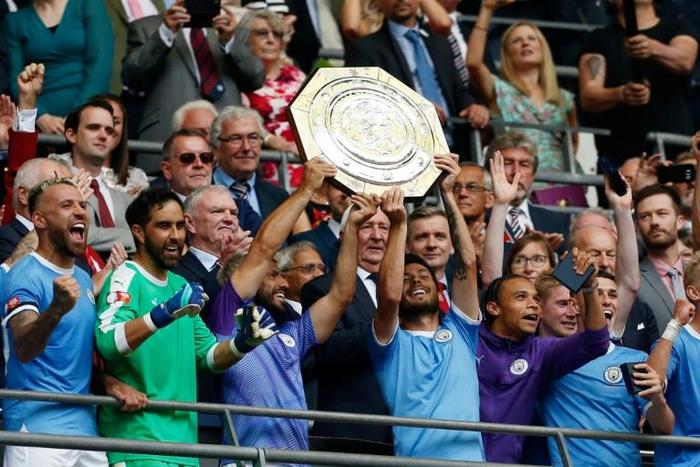 Manchester City's Argentinian striker Sergio Aguero (CL) and Manchester City's Spanish midfielder David Silva (CR) raise the trophy after winning the English FA Community Shield football match between Manchester City and Liverpool