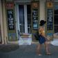 A woman walks past a cigar lounge and bar protected by sand bags in the French Quarter of New Orleans, in preparation for tropical storm Barry