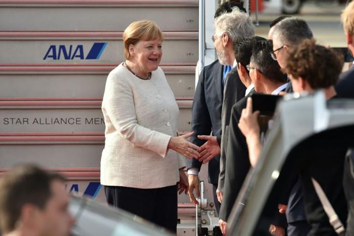 Germany's Chancellor Angela Merkel (L) is greeted by well-wishers upon her arrival in Japan for the G20 summit as officials sought to play down fears over her health