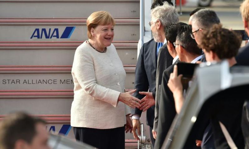 Germany's Chancellor Angela Merkel (L) is greeted by well-wishers upon her arrival in Japan for the G20 summit as officials sought to play down fears over her health