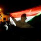 A man holds the Sudanese flag during a night-time demonstration outside the army headquarters in Khartoum on May 30, 2019