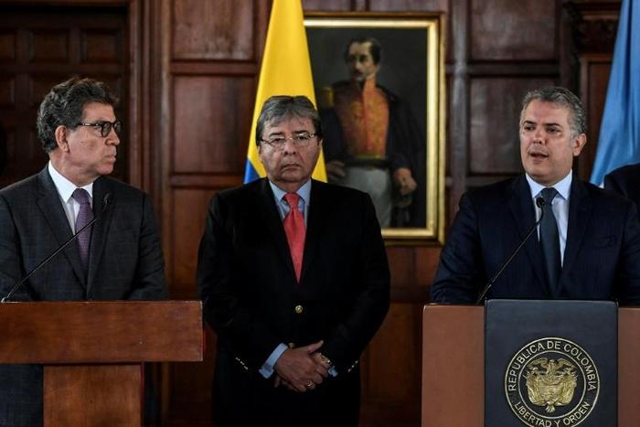 Colombia Foreign Minister Carlos Holmes Trujillo (C) listens as President Ivan Duque (R) speaks next to the president of UN Security Council Gustavo Meza during a press conference in Bogota on July 12, 2019