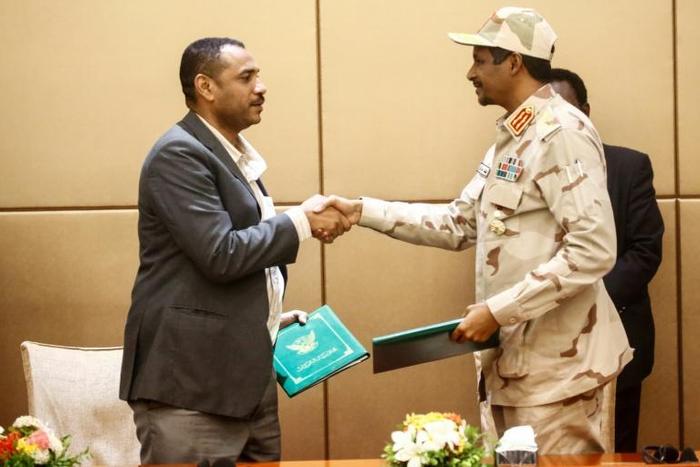 General Mohamed Hamdan Daglo (R), deputy head of Sudan's ruling military council, and protest movement leader Ahmed Rabie shake hands after signing the constitutional declaration at a ceremony in Khartoum