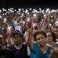 People hold up their phones during a prayer and candle vigil organized by the city, after a shooting left 20 people dead at the Cielo Vista Mall Wal-Mart in El Paso, Texas, on August 4, 2019