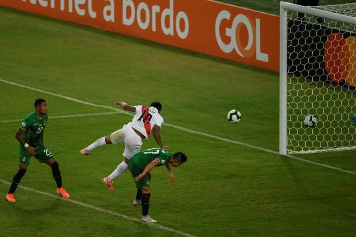 Peru's Jefferson Farfan (center) jumps over Bolivia's Marvin Bejarano to head home the decisive goal at the Copa America