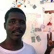 A rescued migrant Arun Mohamed next to his drawing of war in Sudan's Darfur region