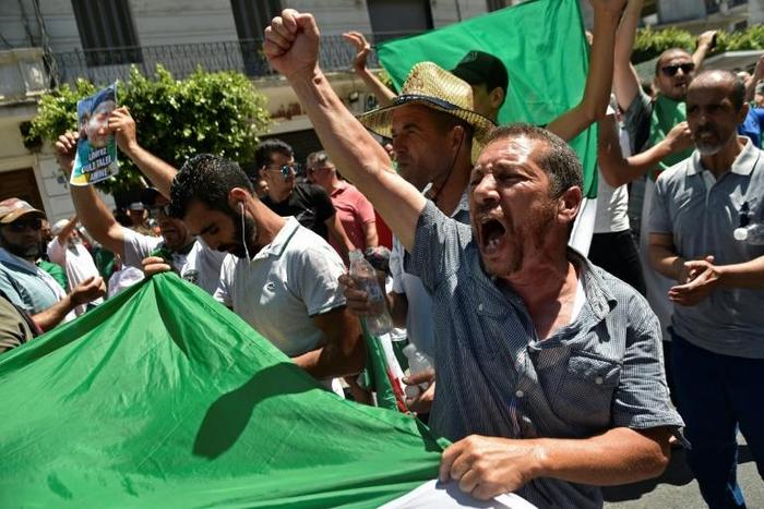 Algerians -- seen here carrying the national flag -- protested against the authorities for a nineteenth consecutive week on Friday