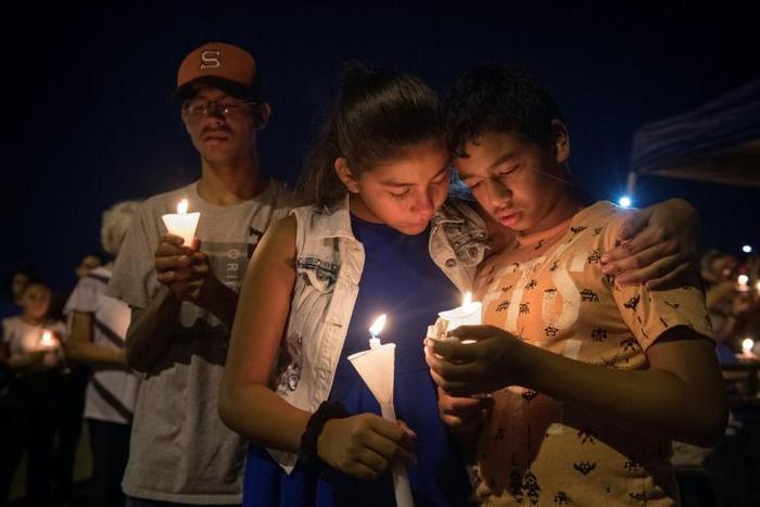 People hold candles as they pray during a candlelight vigil at the Immanuel Church for victims of a shooting that left a total of 22 people dead at the Cielo Vista Mall WalMart in El Paso, Texas, on August 5, 2019