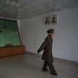 A Korean People's Army soldier walks past a map of the joint security area and Demilitarized Zone (DMZ) separating North and South Korea, in Panmunjom
