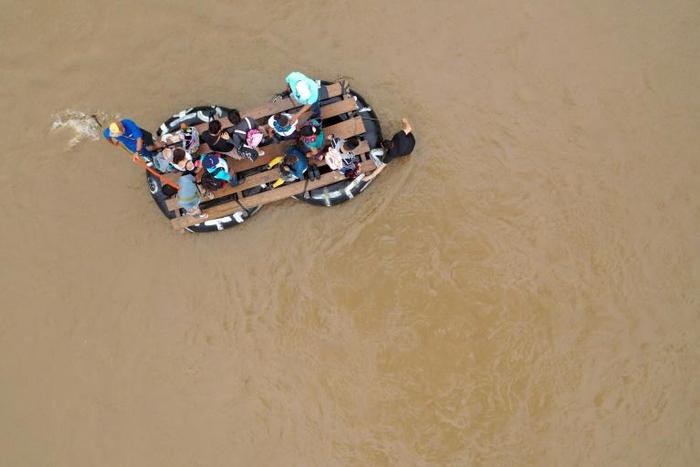 Migrants use an improvised raft to cross the Suchiate river from Tecun Uman in Guatemala to Ciudad Hidalgo in Mexico