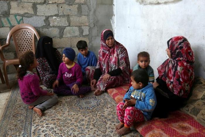 Angham Zorab (L) sits with family members at their modest home in the southern Gaza Strip refugee camp of Khan Yunis