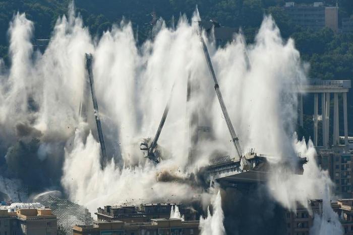 The remains of the 4,500-tonne bridge collapsed in seconds as officials and locals watched the demolition from a distance