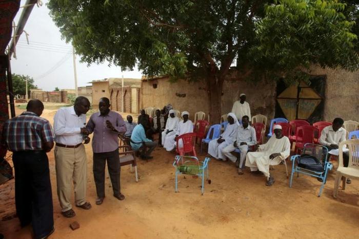 People gather to offer condolences in front of the family home of a slain Sudanese school pupil in the central city of Al-Obeid
