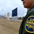 A US Border Patrol officer stands near prototypes of President Donald Trump's proposed wall, in San Diego, California in November 2017
