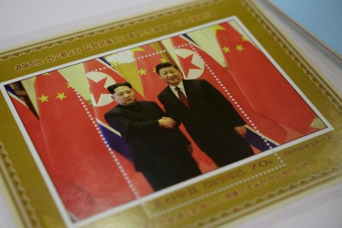 A shop in Pyongyang displays a commemorative stamp featuring North Korean leader Kim Jong Un meeting with Chinese President Xi Jinping ahead of their summit