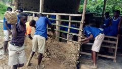 Pupils mould blocks with mud to construct their classroom