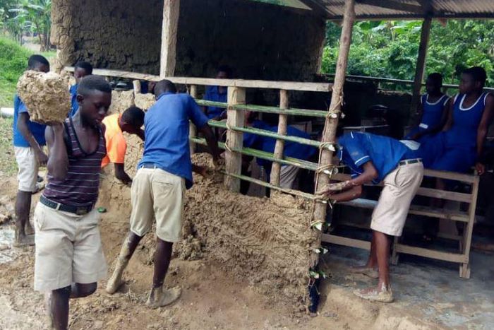 Pupils mould blocks with mud to construct their classroom