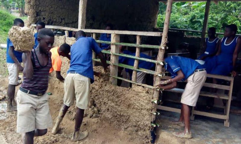 Pupils mould blocks with mud to construct their classroom