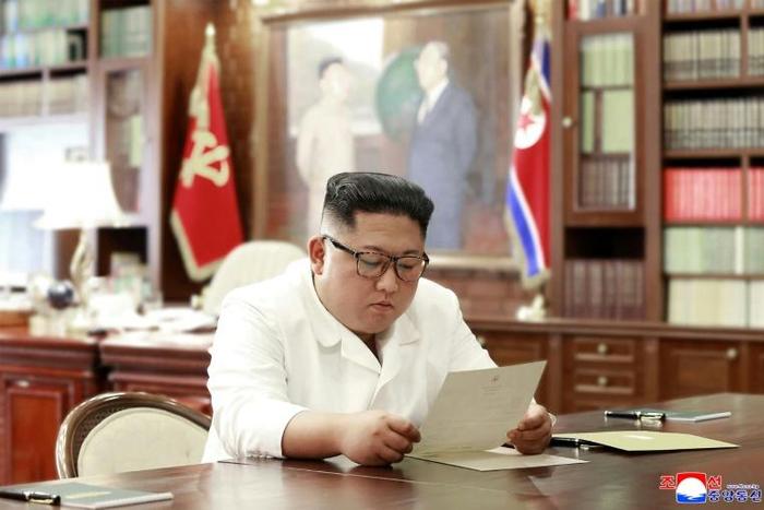 This undated and unlocated picture released from North Korea's official Korean Central News Agency (KCNA)on June 23, 2019 shows North Korean leader Kim Jong Un reading a personal letter from President of the United States of America Donald Trump.