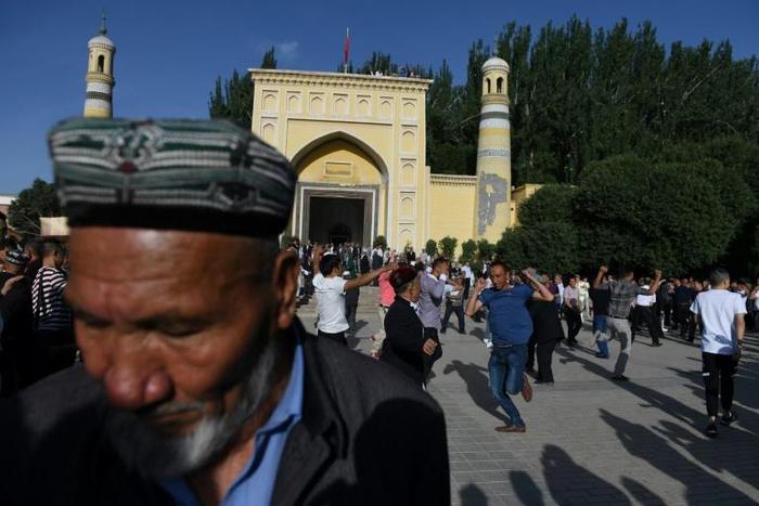 Uighur men dance after Eid al-Fitr prayers, marking the end of Ramadan, at the Id Kah mosque in Kashgar