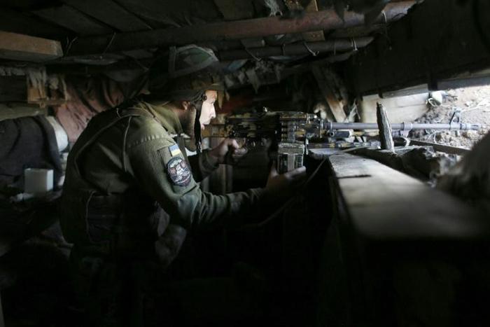 A Ukrainian serviceman monitors the positions of Russia-backed separatists