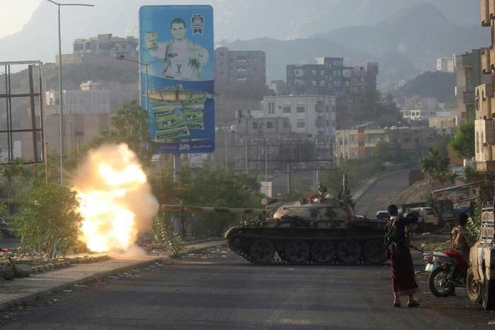 Yemeni fighters loyal to exiled President Abedrabbo Mansour Hadi fire from a tank during clashes with Shiite Huthi rebels in the country's third-city of Taez