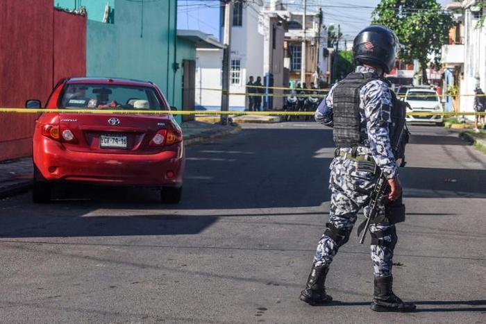 A Naval police officer stands guard near the vehicle in which Mexican journalist Marcos Miranda Cogco was driving his granddaughter to school when he was kidnapped by armed men, in Boca del Rio, Veracruz State, Mexico, on June 12, 2019