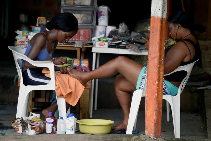 Migrants from Haiti and African countries stuck in the Mexican town of Tapachula do menial work to get by, such as giving pedicures
