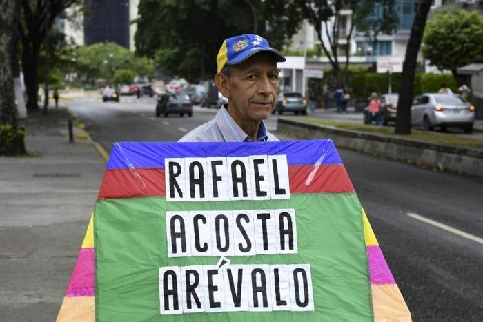 An opposition activist carries a kite with the name of recently deceased navy captain Rafael Acosta in Caracas: the US said it will impose snactions on the intelligence agency accused or torturing him to death