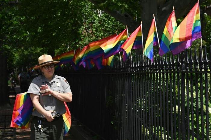 A park ranger places rainbow flags at the Stonewall National Monument, the first LGBTQ national monument, dedicated to the birthplace of modern lesbian, gay, bisexual, transgender, and queer civil rights movement on June 4, 2019 in New York City