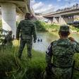 Mexican National Guard watch as Central American migrants try to cross the Rio Grande river from Matamoros, Mexico into the United States in July