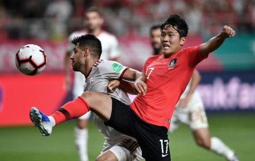 South Korea's Na Sang-ho (red shirt) fights for the ball against Iran's Morteza Pouraliganji during their friendly international in Seoul on June 11, 2019. The match ended 1-1