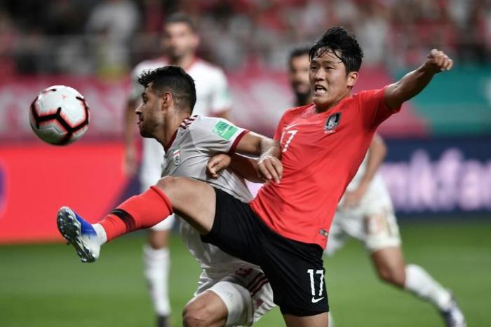 South Korea's Na Sang-ho (red shirt) fights for the ball against Iran's Morteza Pouraliganji during their friendly international in Seoul on June 11, 2019. The match ended 1-1