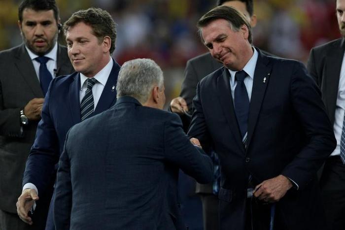 Brazil coach Tite (center) shakes hands with Brazilian President Jair Bolsonaro (right) after leading his team to Copa America glory