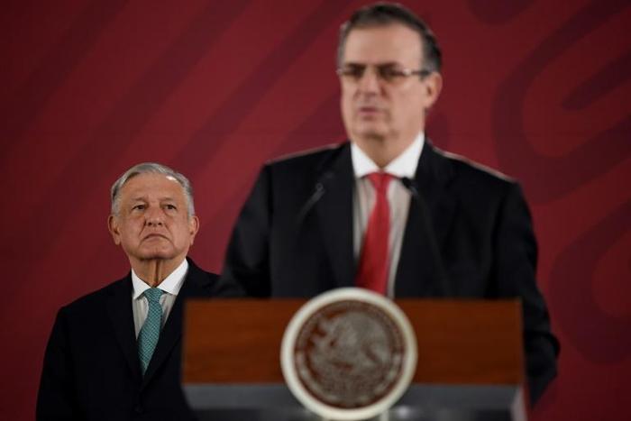 Mexican President Andres Manuel Lopez Obrador (L) listens to Foreign Minister Marcelo Ebrard during a press conference in Mexico City on an immigration deal with the US