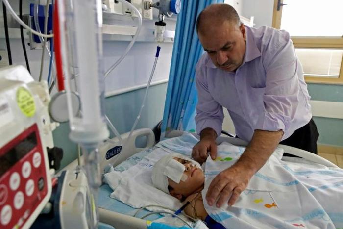 Yassir Shtewi sleeps each night by his son's bed in an Israeli hospital