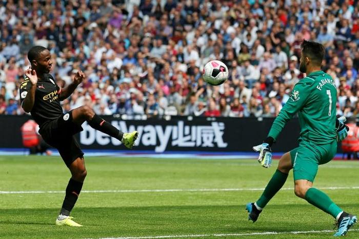 Manchester City's Raheem Sterling lifts the ball over Lukasz Fabianski to score their third goal at West Ham