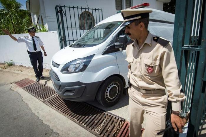 Moroccan security personnel stand guard as a car transporting the suspected killers leaves the court in Sale on May 16