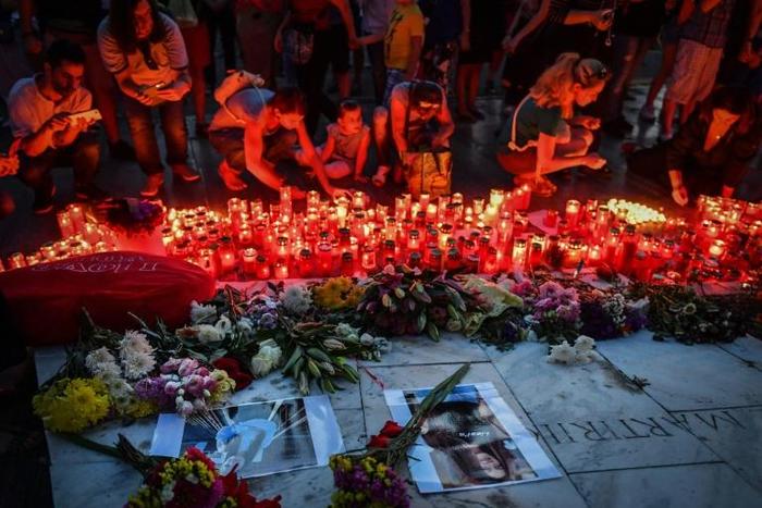 People light candles at a makeshift memorial in front of the Romanian Interior Ministry in Bucharest on July 27 to commemorate Alexandra, the 15-year-old girl who was murdered after she telephoned police three times to report her own kidnapping.