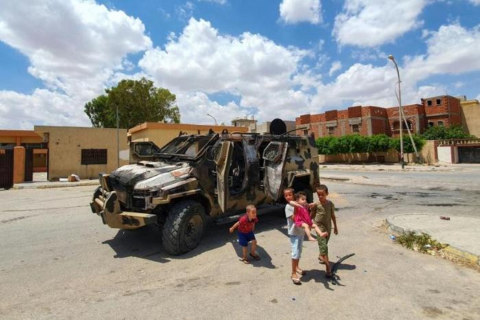Libyan children play next to a burnt out vehicle belonging to forces loyal to strongman Khalifa Haftar in Gharyan, 100 kilometres (60 miles) southwest of Tripoli, earlier this year