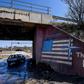 A car drives past graffiti reading "Thank You NATO" and featuring the US flag near the village of Stagovo, Kosovo on March 24, 2019, 20 years after the start of the alliance's bombing campaign