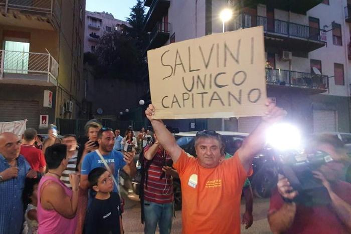 A man holds a placard reading "Salvini is the only captain"