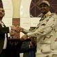 Sudanese deputy chief of the ruling miliary council Mohamed Hamdan Dagalo and protest movement Alliance for Freedom and Changes leader Ahmad al-Rabiah shake hands after inking a power-sharing agreement