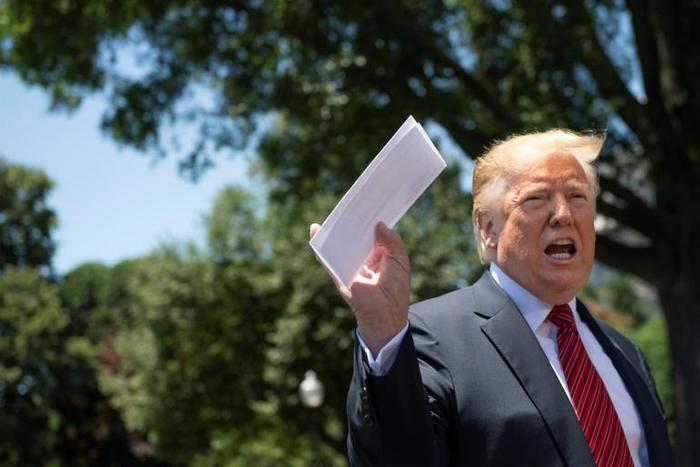 US President Donald Trump holds piece of paper saying it's his deal with Mexico as he speaks with reporters at the White House