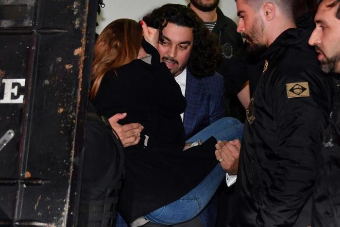 The woman who has accused Brazilian football star Neymar of rape, Najila Trindade Mendes de Souza, is carried out of a Sao Paulo police station by her lawyer Danilo Garcia de Andrade -- he has now abandoned her as a client
