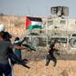 Palestinian demonstrators throw stones at Israeli security forces during protests along the border with Israel east of Khan Yunis, in the southern Gaza Strip