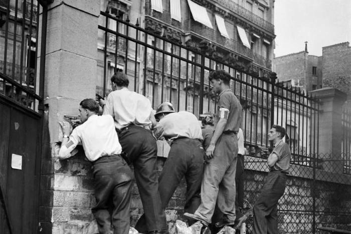French Resistance fighters take position behind a wall in August 1944 during the battle for the liberation of Paris from Nazi occupation during World War II