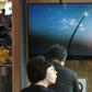 People watch file footage of a North Korean missile launch on television news at a station in Seoul