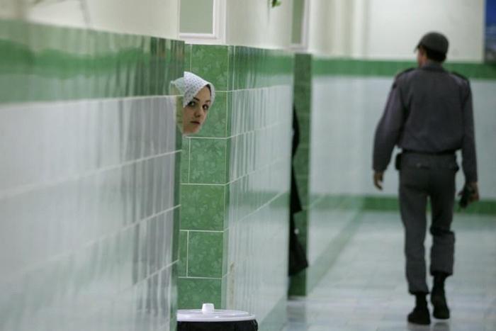 A prisoner peeks out at the hallway at Tehran's Evin prison in June 2006