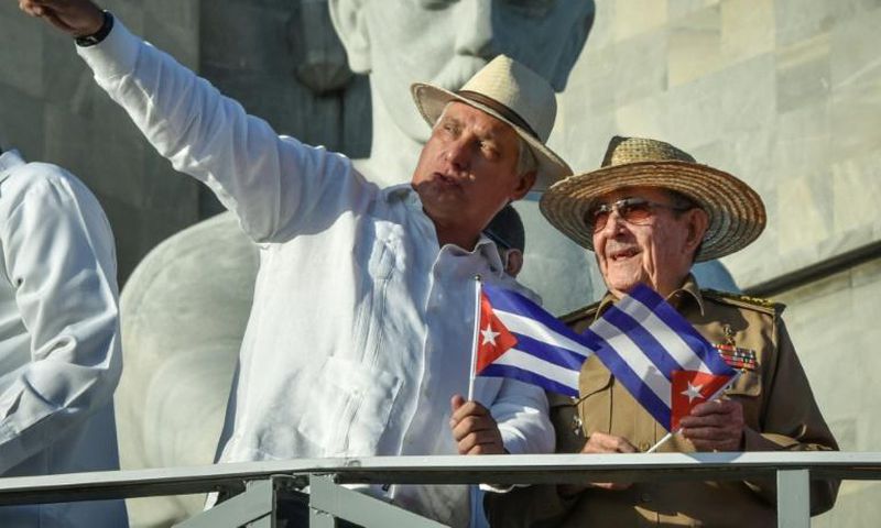 Cuban President Miguel Diaz-Canel (with his arm raised) stands next to Raul Castro, first secretary of the island's Communist Party, on May 1, 2019 in Havana; a new law will bring governmental change without touching the central role of the party